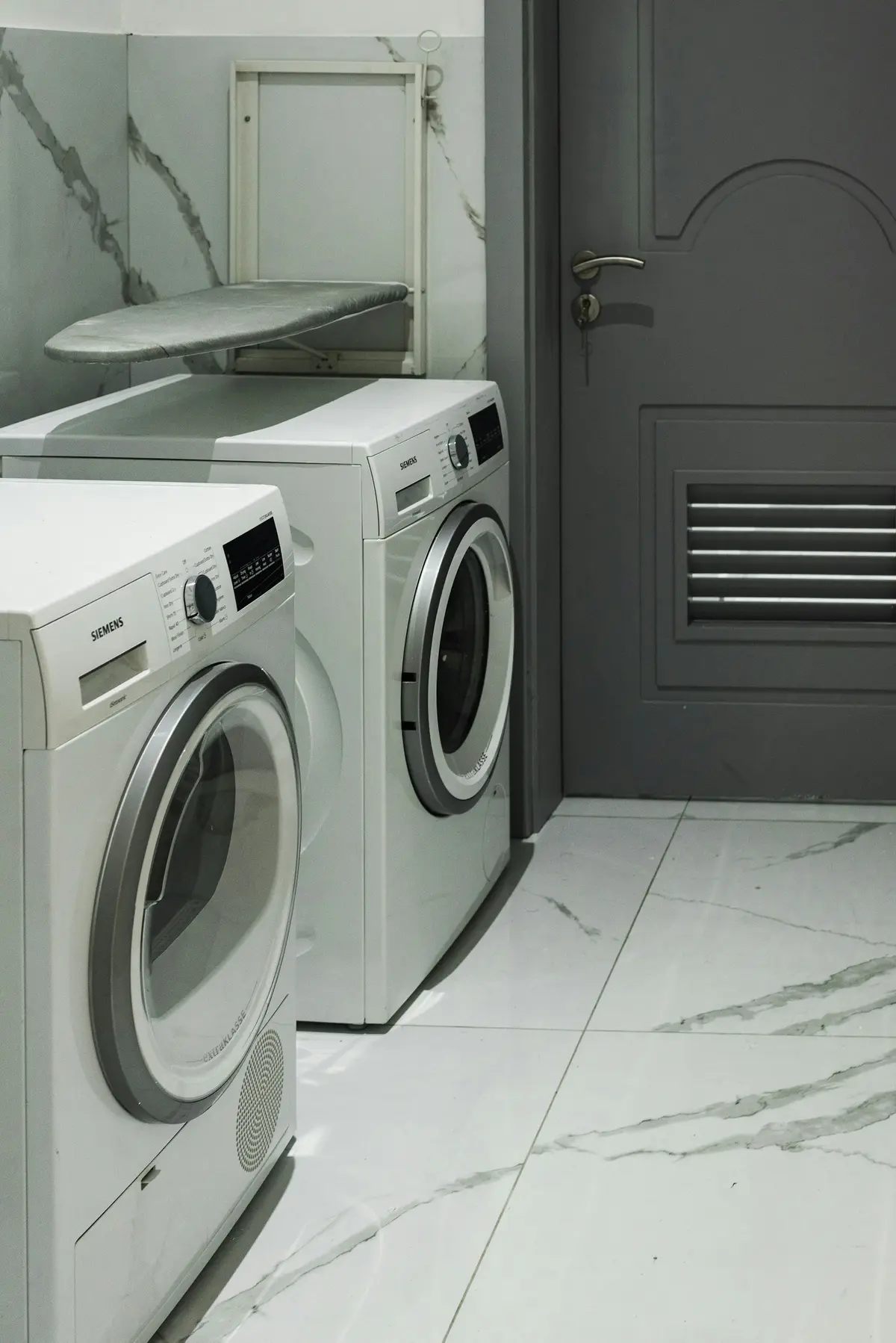 Washer and dryer on a marble-look tile floor